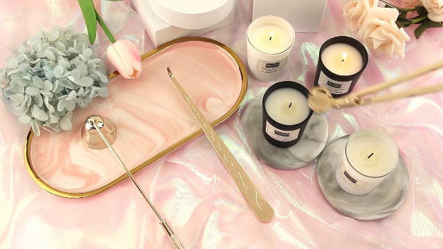 Candle care kit with wick trimmer beside sparkspitter candle on safe surface