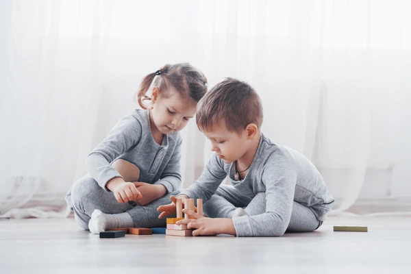 Toddler playing with safe wooden blocks and sensory toys for creative learning.