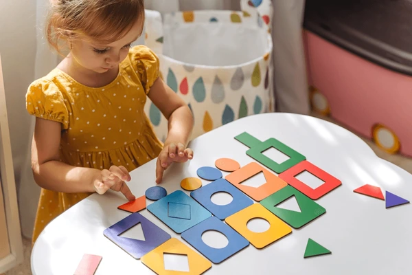 Toddler playing with colorful shape sorters and counting bears for early math.